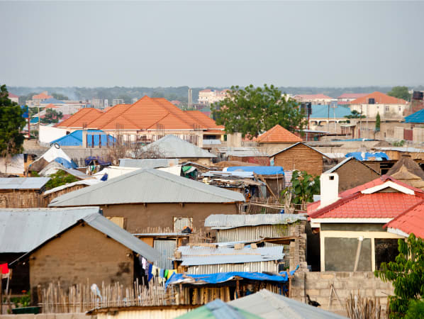 Houses in Juba, South Sudan. A combination of red shingled roofs and tin roofs, and tarps. 
